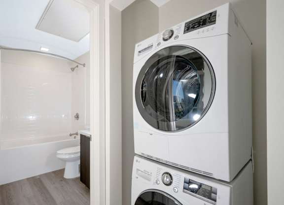 A white washing machine and dryer in a small bathroom.