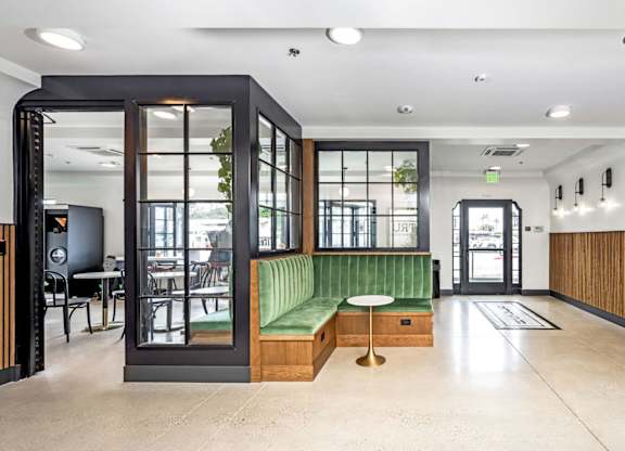 A modern interior with a green bench and a wooden floor.
