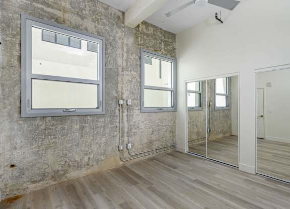 A room with a white door, a mirror, and a window.