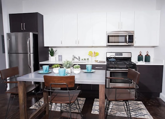 A modern kitchen with a table set for two.