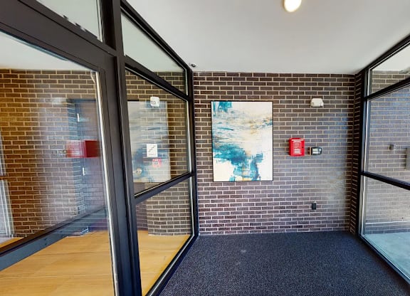 A hallway with a blue carpet and a painting on the wall.