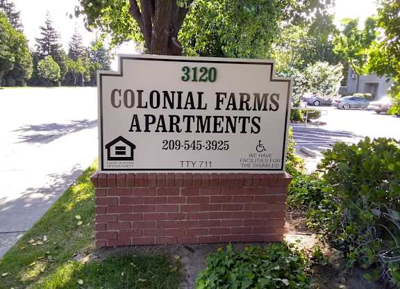 Colonial Farms Apartments - address sign with phone number 209-545-3925 and TTY 711