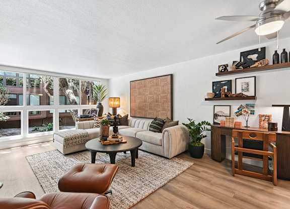 A living room with a brown leather chair and a white couch.