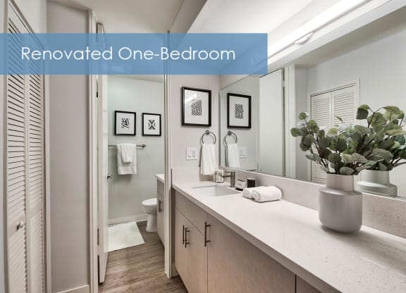 an image of a bathroom with a sink and a vase of flowers at The Meadows Apartments, Culver City , CA