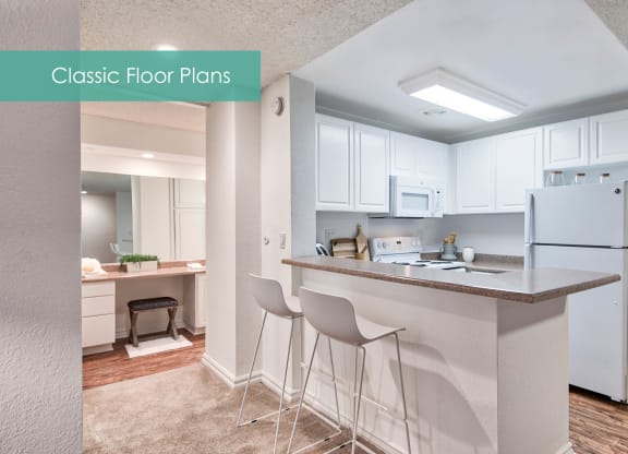 a kitchen with white cabinets and a counter top with bar stools at The Meadows Apartments, Culver City , CA 90230