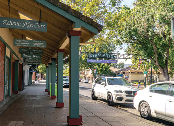 a city sidewalk with cars parked on the street  at Pleasanton Place, Pleasanton, CA