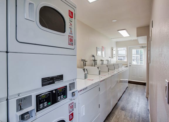 a washer and dryer in a room with a long counter and a kitchen  at Pleasanton Place, Pleasanton, CA