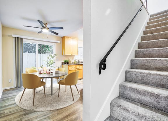 a dining room with a table and chairs next to a staircase  at Pleasanton Place, California