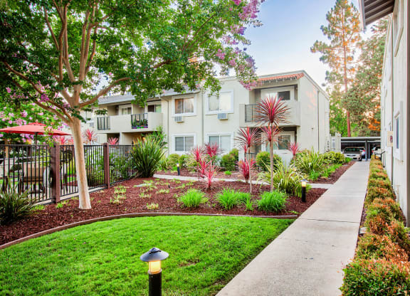 a courtyard with a sidewalk and a building with trees and plants at Pleasanton Place, Pleasanton, CA, 94566