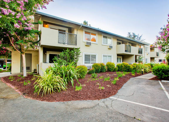 an exterior view of an apartment building with a driveway and landscaping  at Pleasanton Place, California, 94566