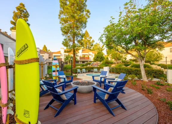 a patio with a surfboard and chairs on a deck at Sendero Huntington Beach, Huntington Beach, CA 92647