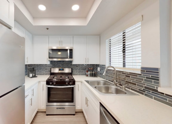 the kitchen has stainless steel appliances and white cabinets at Sendero Huntington Beach, Huntington Beach, 92647