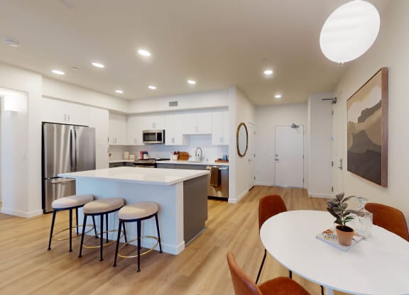 a kitchen and dining area with a table and stools at The Villas at Anacapa Canyon, Camarillo