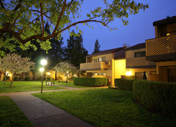 the apartments are lit up at night and the courtyard is empty at Valley Plaza Villages, California, 94566