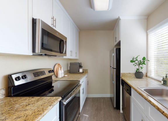 a kitchen with stainless steel appliances and granite counter tops at Valley Plaza Villages, California