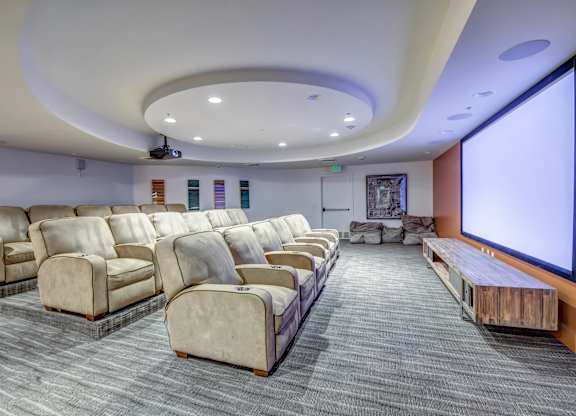 A movie theater with rows of seats and a large screen. at Esprit Apartments, California