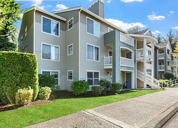 A large apartment building with a well-maintained lawn in front.