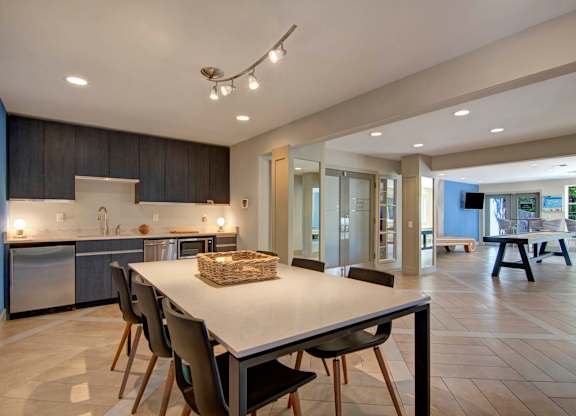 A modern kitchen with a dining table and chairs.