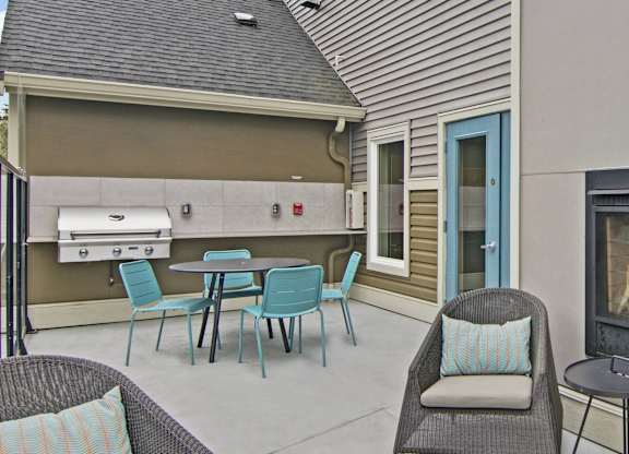 A patio with a table and chairs and a fireplace.
