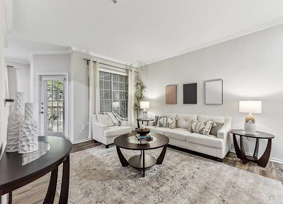 A living room with a white couch, a coffee table, and a rug. at Stone Oak @ Parmer, Austin, Texas