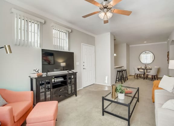 a living room with a ceiling fan and a tv  at Adiamo Palm Valley, Goodyear, AZ