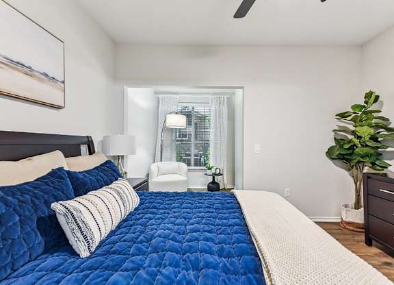 A bedroom with a large bed and a ceiling fan. at Stone Oak @ Parmer, Austin, Texas