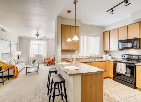 an open kitchen and living room with a large counter top  at Adiamo Palm Valley, Goodyear, Arizona