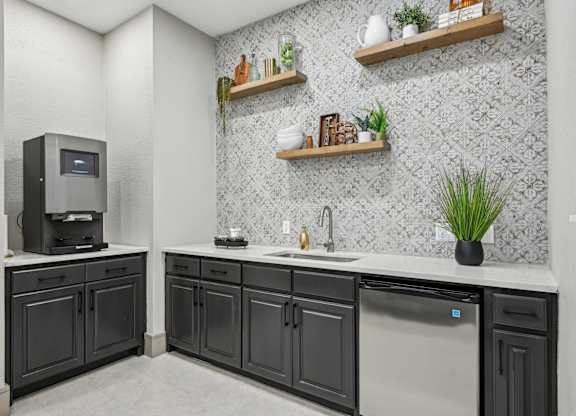 A kitchen with black cabinets and a stainless steel dishwasher.