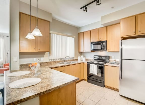 full kitchen with granite counter tops and stainless steel appliances  at Adiamo Palm Valley, Goodyear