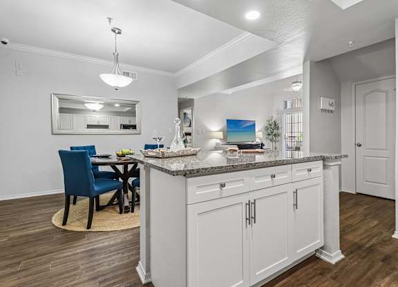 A kitchen with a blue chair and white cabinets.