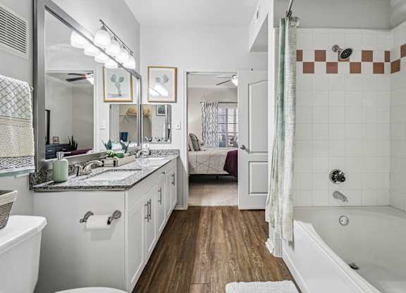 A bathroom with a white tub and a white sink.