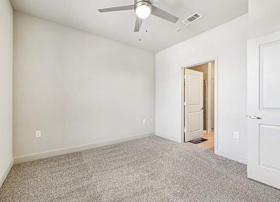 A room with a ceiling fan and carpeted floor.at North Creek, Hutto