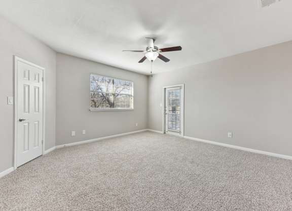 A room with a ceiling fan and carpeted floor. at Sonterra Apartment Homes, Texas