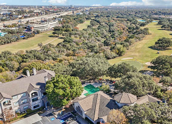 A bird's eye view of a residential area with houses and a swimming pool at TalaVera Apartments, San Antonio, Texas