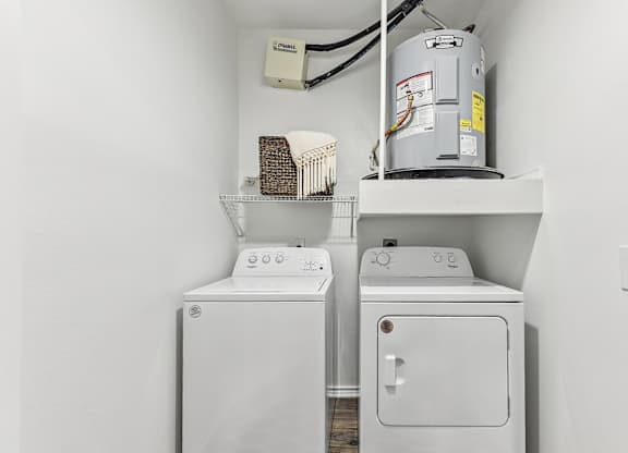 A white washing machine and dryer in a small laundry room. at Stone Oak @ Parmer, Austin, Texas