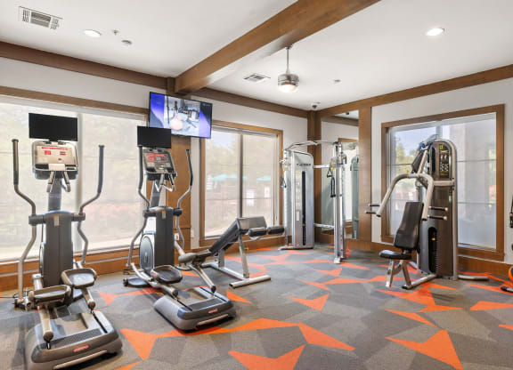 a home gym with exercise equipment and windows at Lakeline East Apartments, Cedar Park, 78613