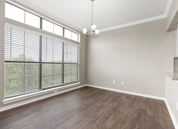 An empty living room with a large window at Waters Edge Apartment Homes, Georgetown, Texas