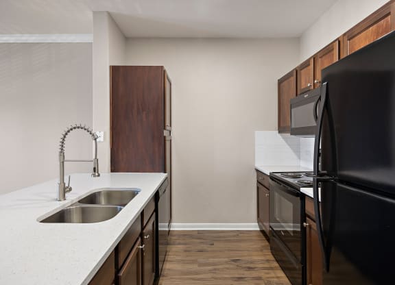 an empty kitchen with black appliances and a white counter top at The Fairways at Star Ranch, Texas