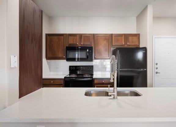 a kitchen with a white counter top and a black refrigerator at The Fairways at Star Ranch, Hutto, Texas