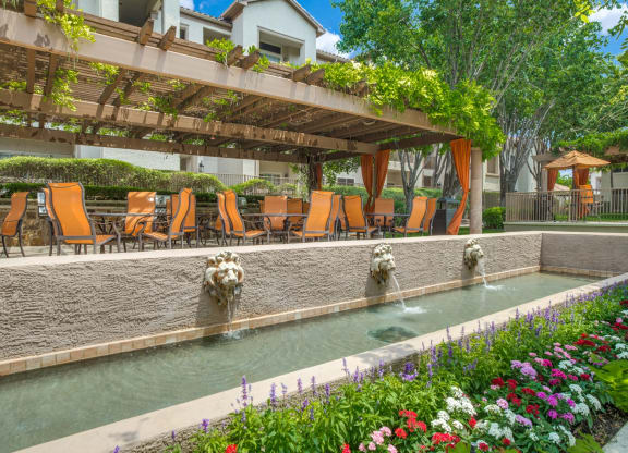 a swimming pool with chairs and water fountains at La Ventura Apartments, Plano, 75093