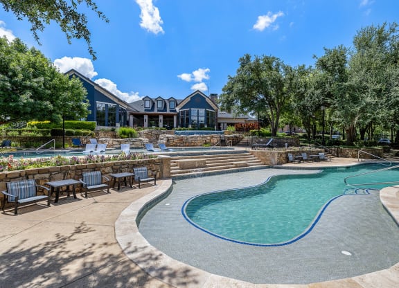 a swimming pool with chairs and a house in the background at The Vista on Brodie, Texas, 78745