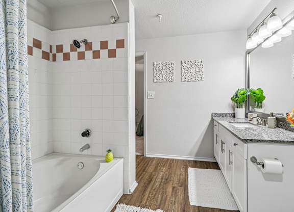 A bathroom with a white tub and a white sink.