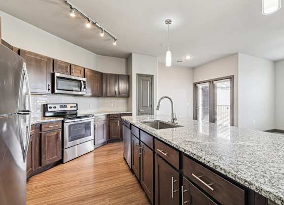 A kitchen with a granite countertop and stainless steel appliances.at North Creek, Hutto, Texas