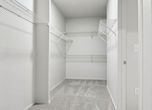 A white hallway with a carpeted floor and a door on the right.