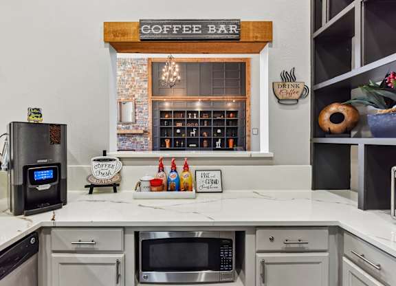 A coffee bar area with a coffee maker and a sign that says