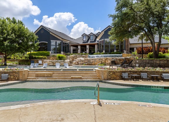 a swimming pool with a house in the background at The Vista on Brodie, Texas