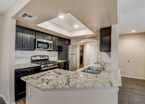 an open kitchen with granite counter tops and black cabinets  at San Montego Apartments, Mesa, 85206