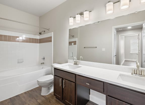 a bathroom with a large mirror and a sink and a toilet at The Verandah, Austin, TX