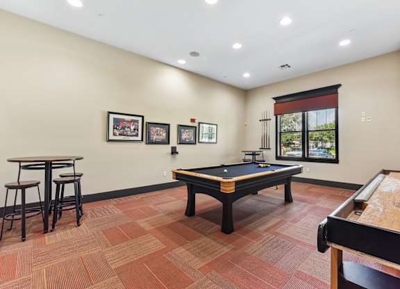 A room with a pool table and a bar.