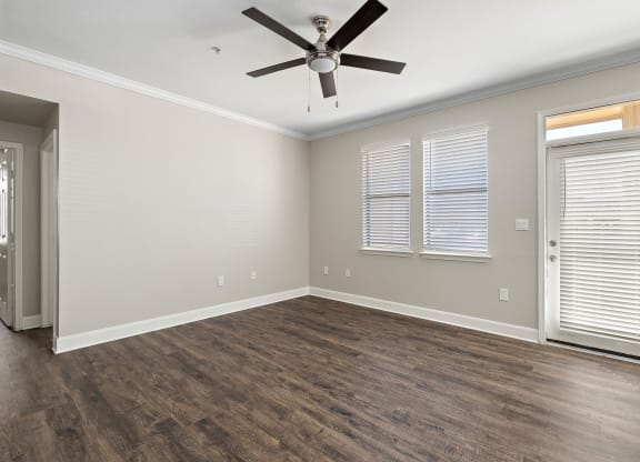 an empty living room with a ceiling fan and window at The Verandah, Texas